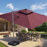 Offset patio umbrella beside an outdoor dining table with a weighted base