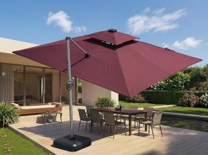 Offset patio umbrella beside an outdoor dining table with a weighted base